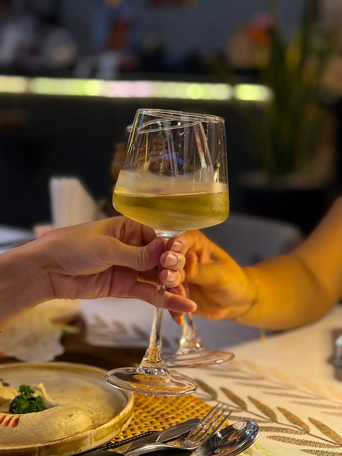 Two glasses of white wine raised in a toast