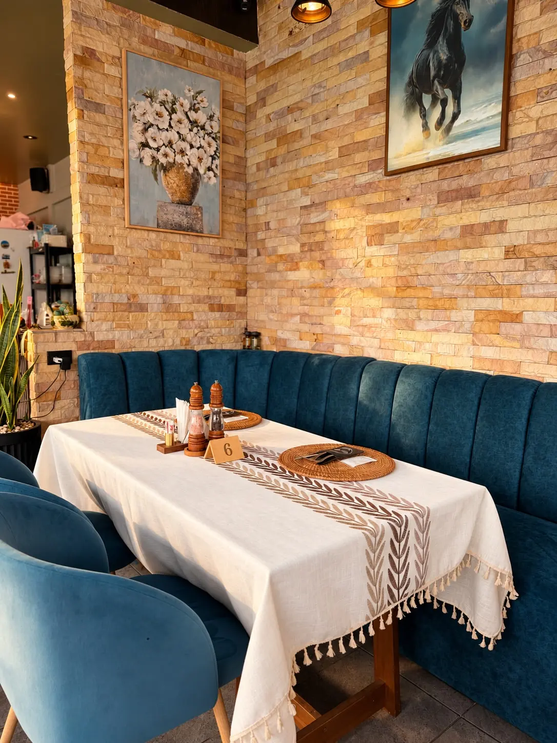 Brick wall and blue velvet banquette inside Moya Kuhnya