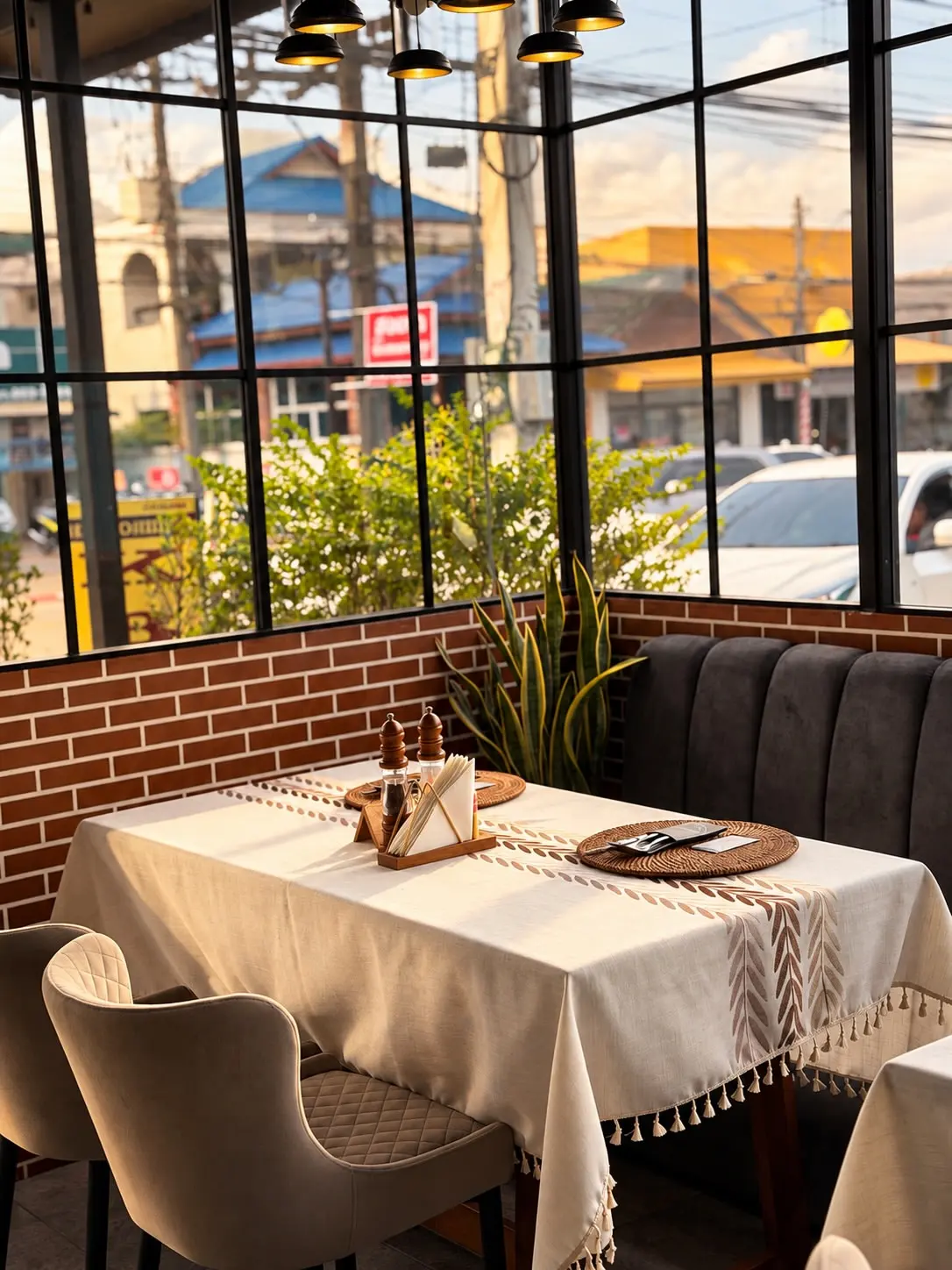 Dining room at Moya Kuhnya with tall windows and linen tables