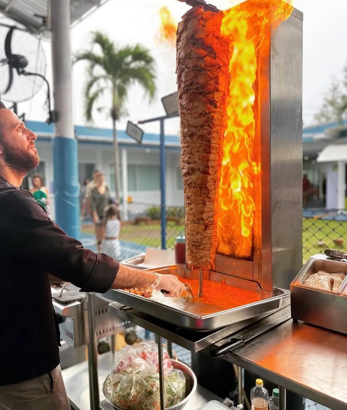Shawarma spit roasting beside open flame